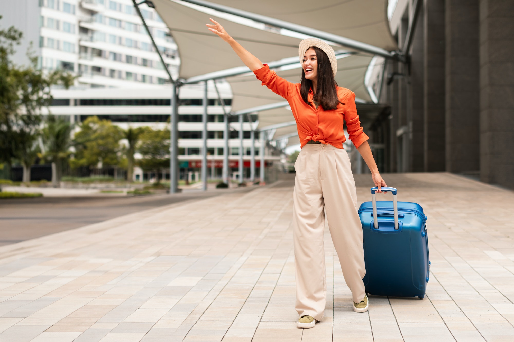 Happy Passenger Lady Catching Taxi Cab With Travel Suitcase Outdoors